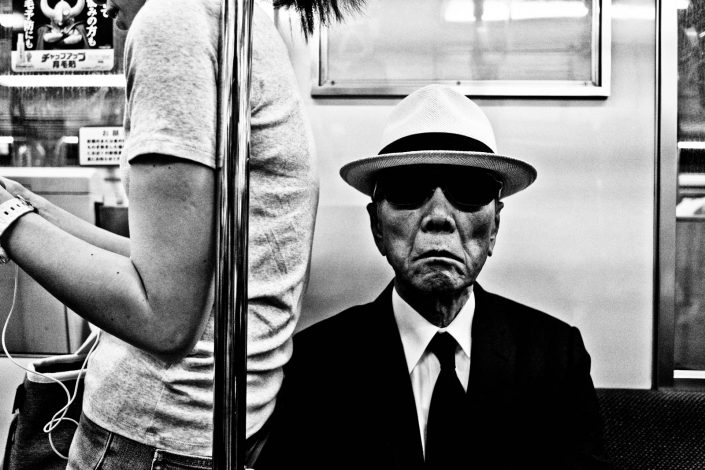 Cool old man with sunglasses and hat in a metro of Tokyo, Japan. Street Photography by Victor Borst