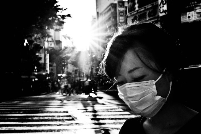 Japanese woman with facemask with low sunlight on Shibuya, Tokyo. Street Photography by Victor Borst