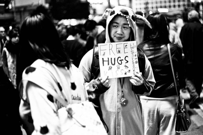 Cosplay Japanese guy with a sign Free hugs & kiss at Shibuya, Tokyo. Street Photography by Victor Borst