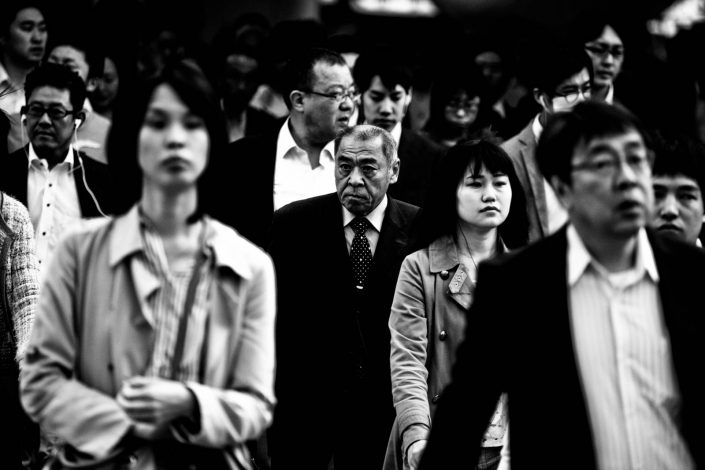 Portrait of an old man within a crowd at Shimbashi station. Street Photography by Victor Borst