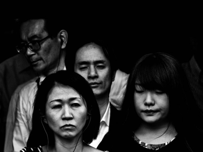 Close up faces of salarymen and women at Shimbashi station. Street Photography by Victor Borst