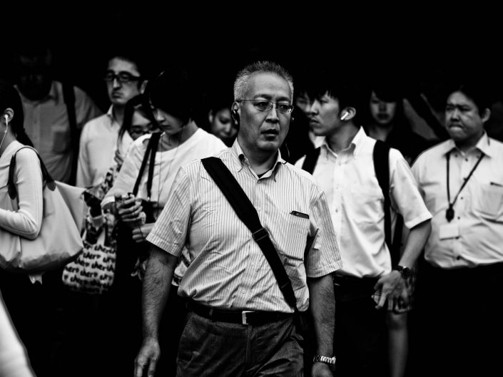 A crowd of salarymen and women all heading to work on a warm day. Street Photography by Victor Borst