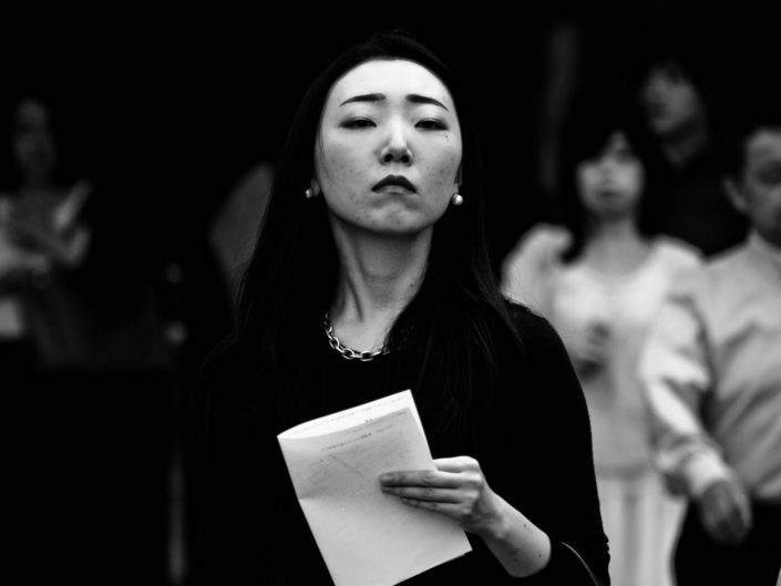strict looking woman with a paper in her hand going to work at Shimbashi station. Street Photography by Victor Borst