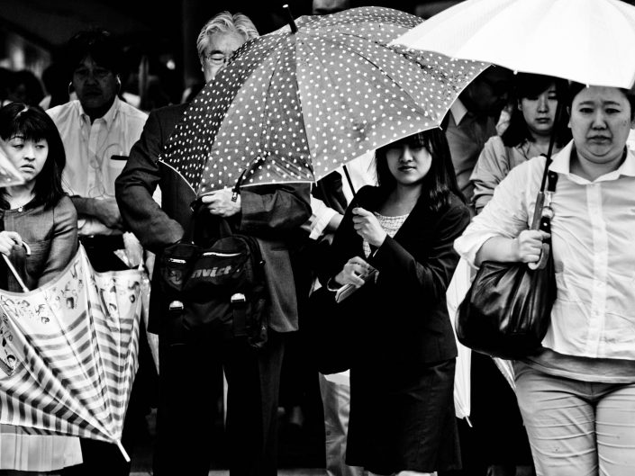 Umbrella people exiting Shimbashi station. Street Photography by Victor Borst