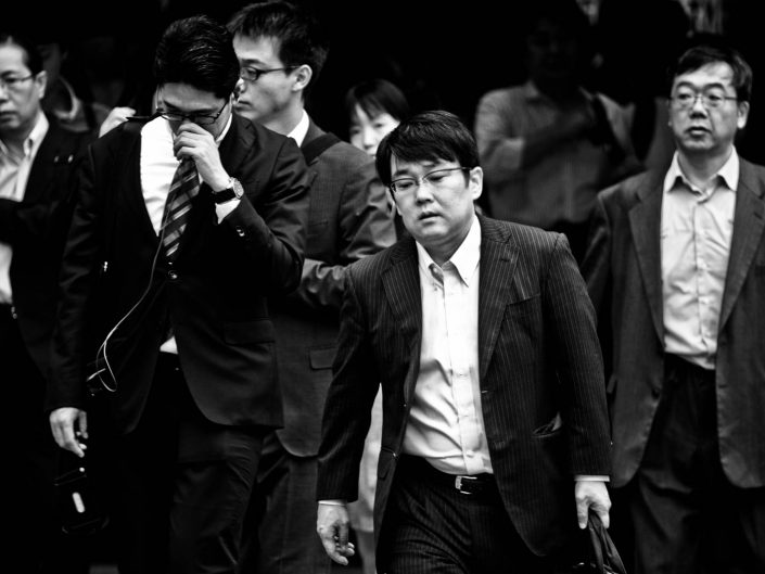 Group of salarymen in suits at shimbashi station heading for work. Street Photography by Victor Borst