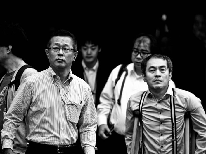 Two salarymen, one with glasses and one with crutches. Street Photography by Victor Borst