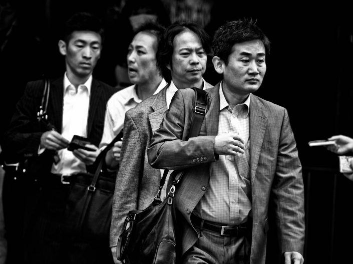 Four salarymen in a row at Shimbashi station going to work. Street Photography by Victor Borst