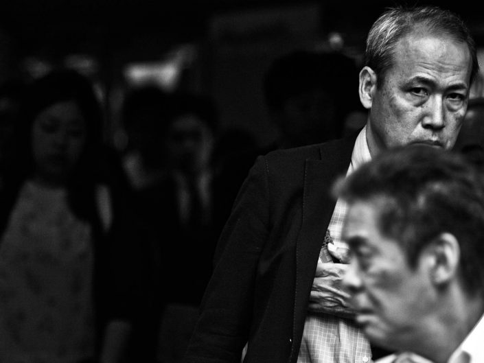 Two faces of salarymen just in the frame at Shimbashi Station. Street Photography by Victor Borst